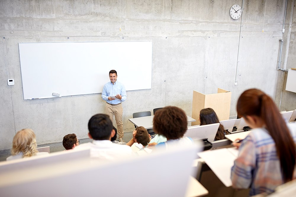 Professor dando aula em um auditório para representar o método de ensino Freiriano.