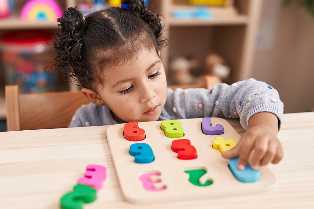 Menina brincando com jogo de numerais para exercitar as habilidades cognitivas.